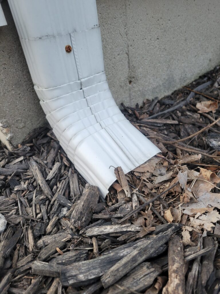 Gutter clogged with leaves and mulch